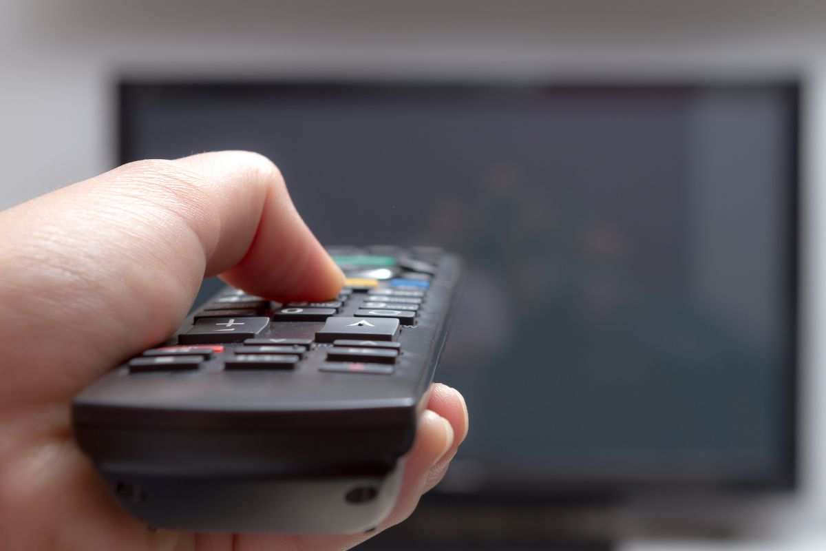 Mano che spegne la televisione