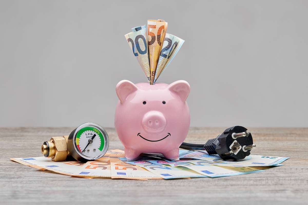 salvadanaio, soldi, spina corrente e barometro gas