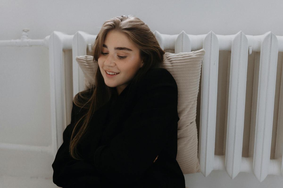 ragazza appoggiata al termosifone